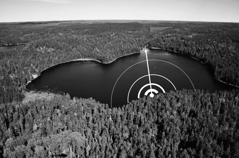 Black and white photo of a freshwater lake surrounded by trees and a white line and half circles 