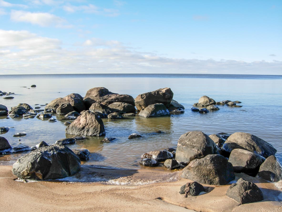Sandy Beach with big rocks and calm waters.